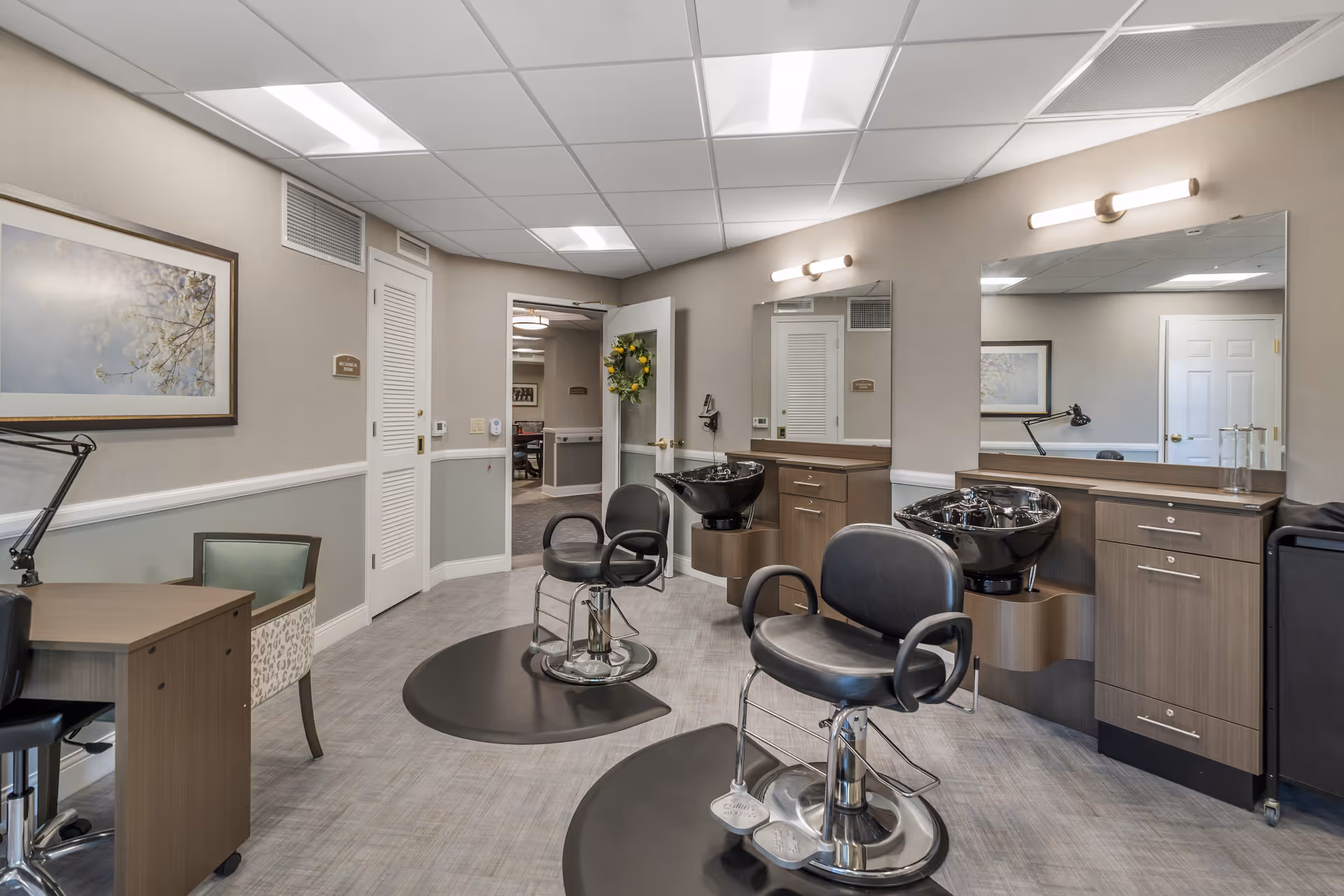 A senior living facility hair salon with chairs, mirrors, sinks, and cabinets.
