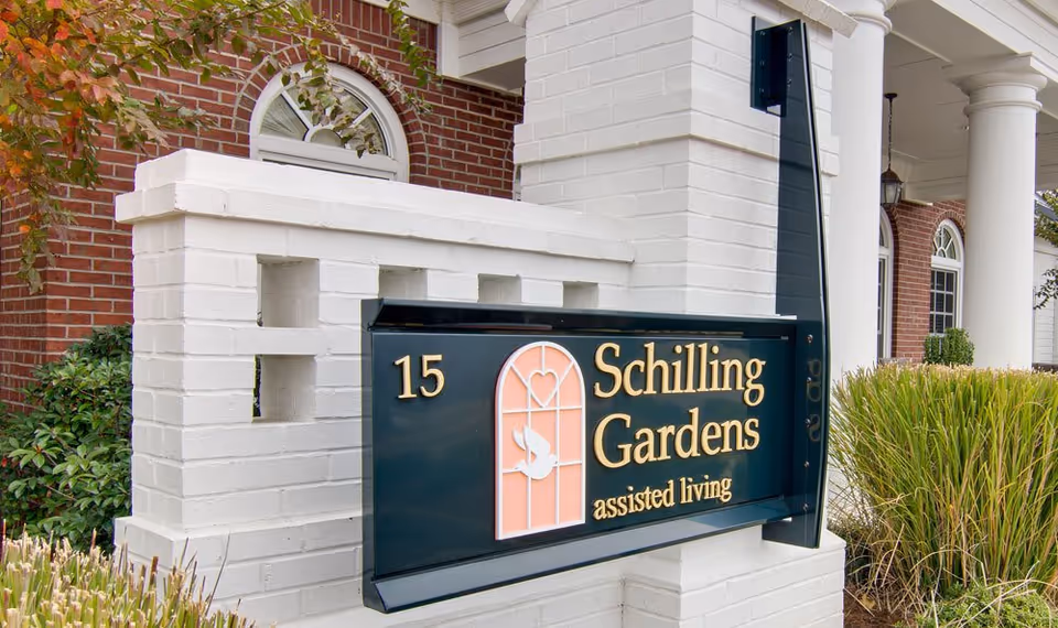 Exterior view of Schilling Gardens assisted living entrance sign beside brick building