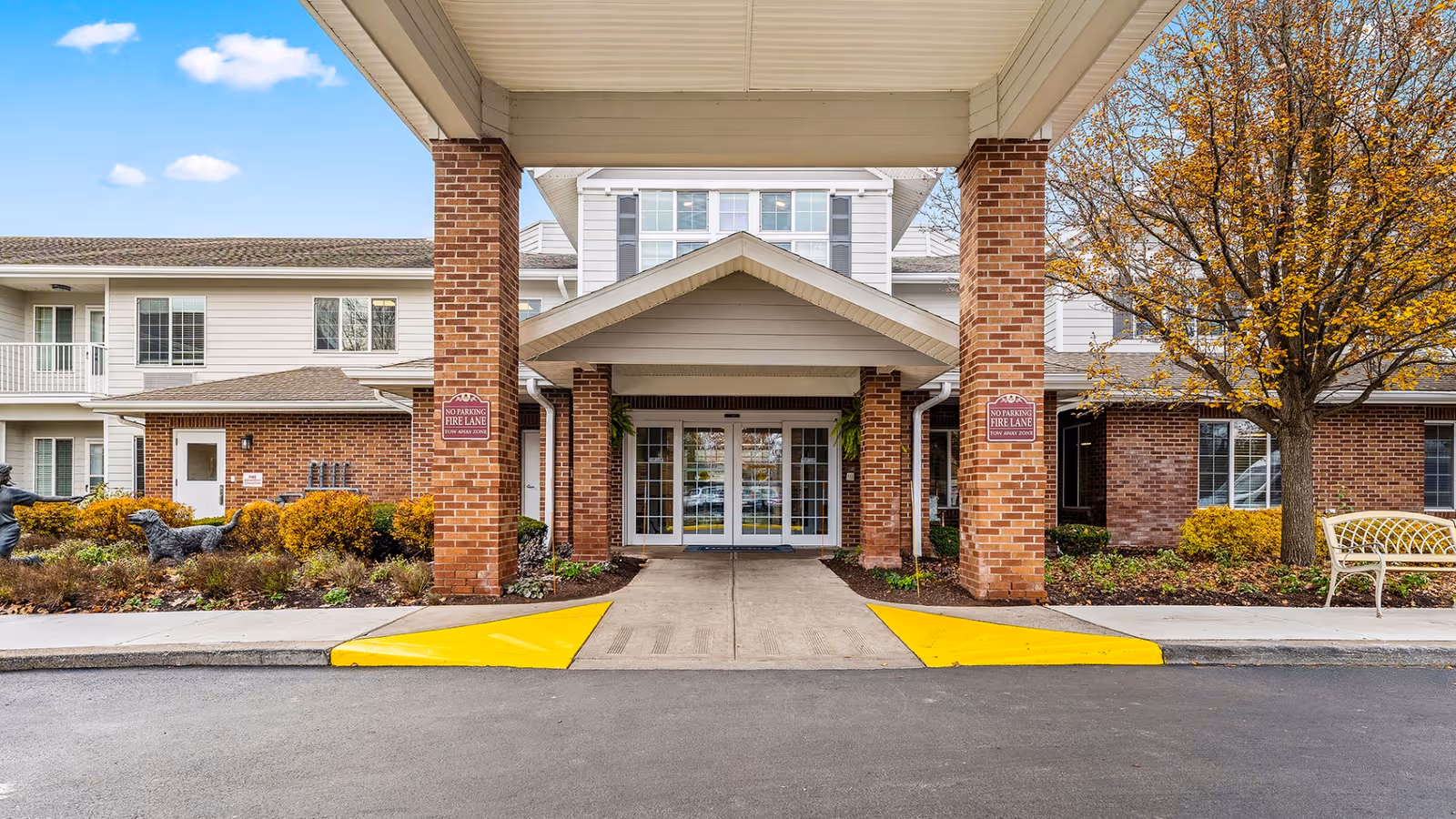 Exterior view of Holiday Maple Downs entrance with brick columns and a covered entry.