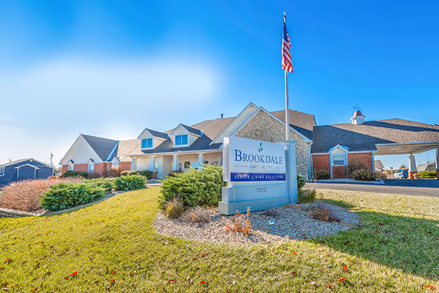 Exterior view of Brookdale Junction City senior living facility with sign and American flag.