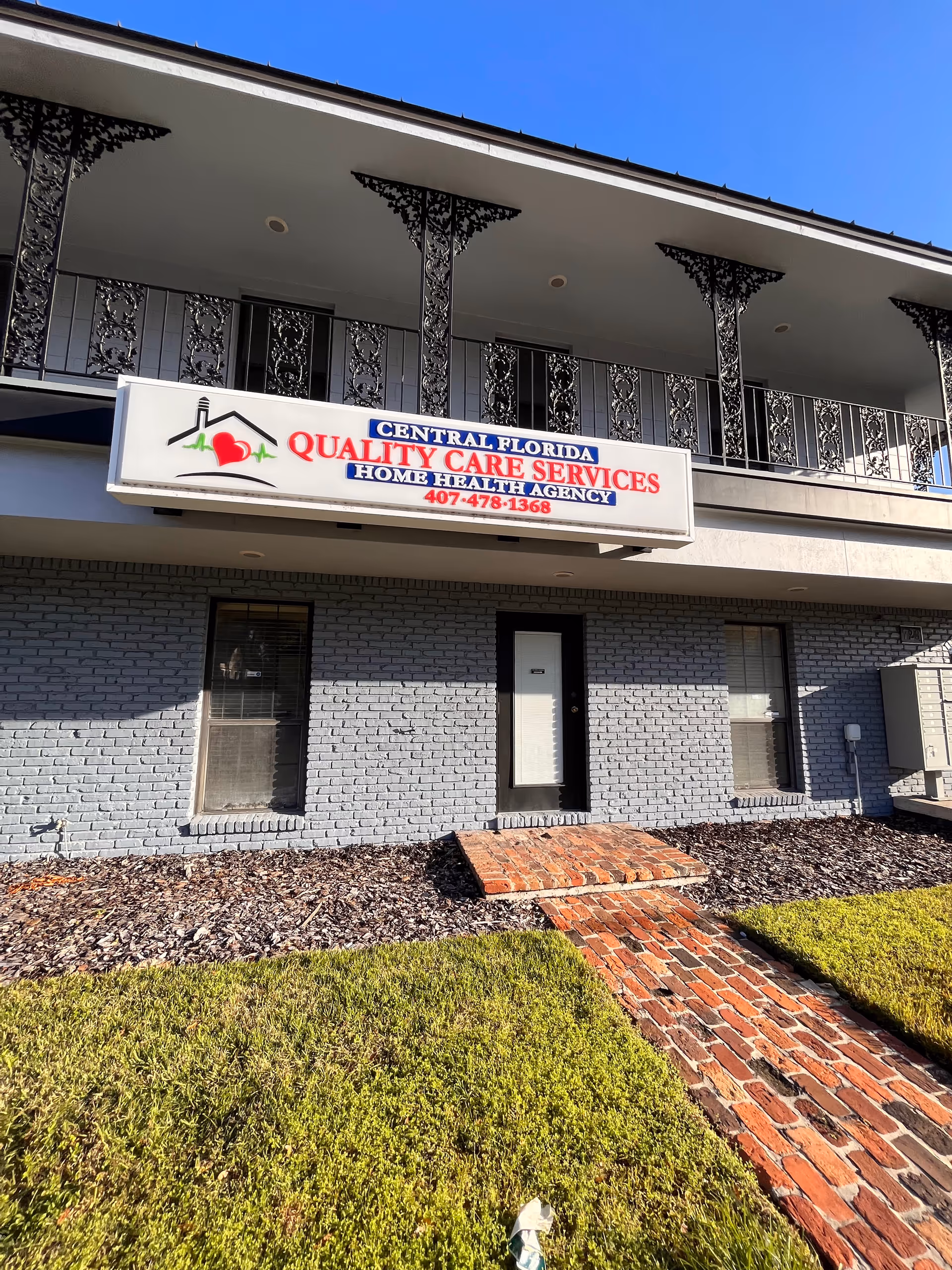 Front exterior of a light-gray brick building with a sign for Central Florida Quality Care Services.