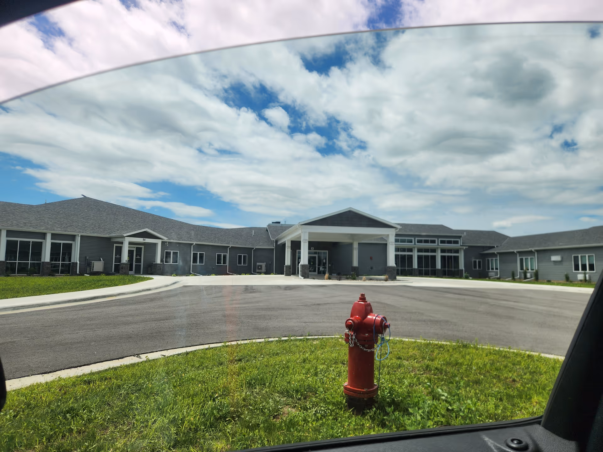 Exterior view of Aase Haugen Homes with a circular driveway and central entrance.