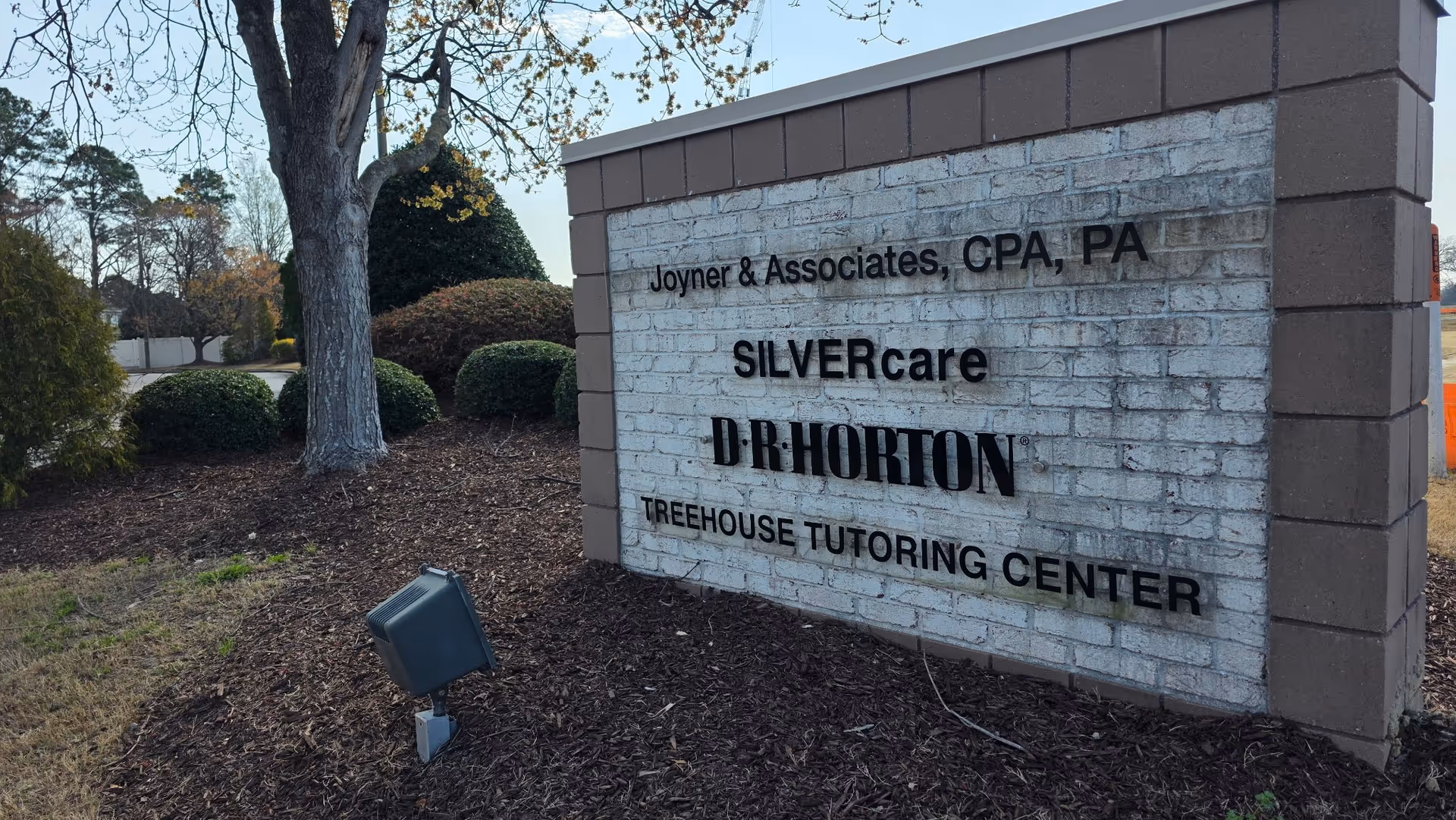 An exterior stone sign displays SILVERcare with landscaping nearby.