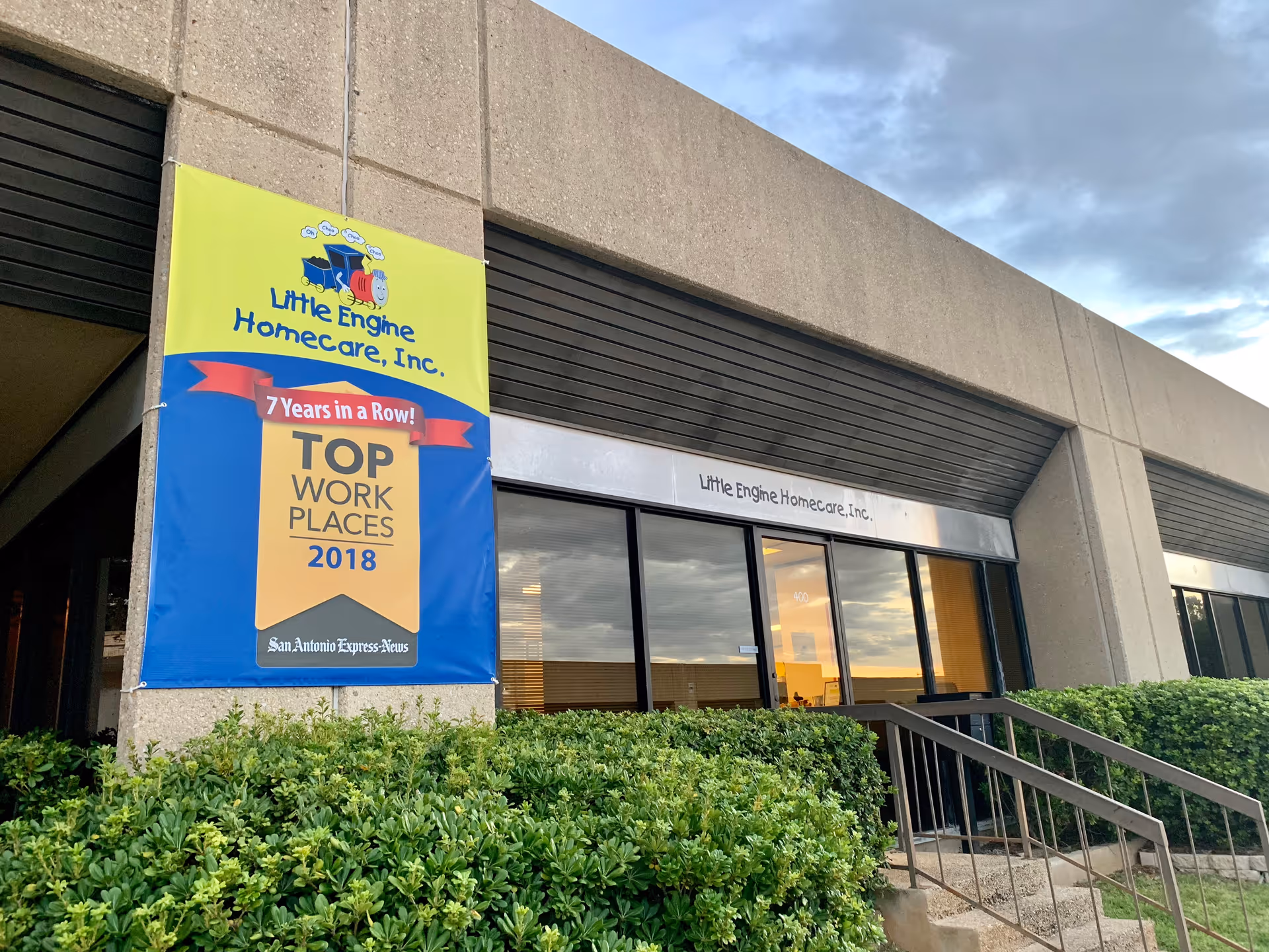 Exterior view of Little Engine Homecare, Inc. building with a banner by the entrance.