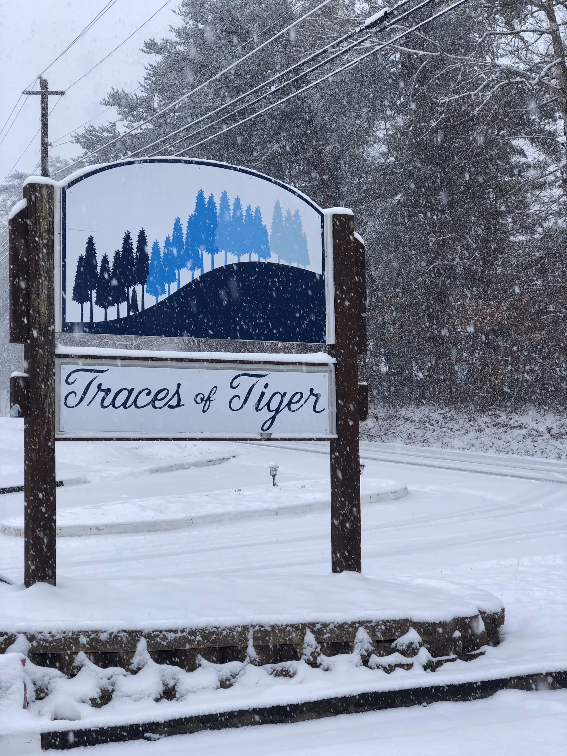 Snowy entrance sign reading Traces of Tiger Retirement at the front.
