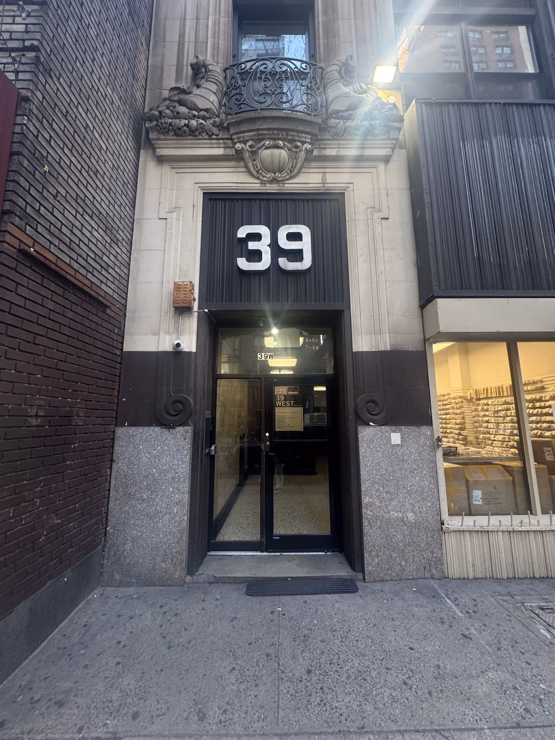 Ornate stone building entrance with a large '39' above glass doors.