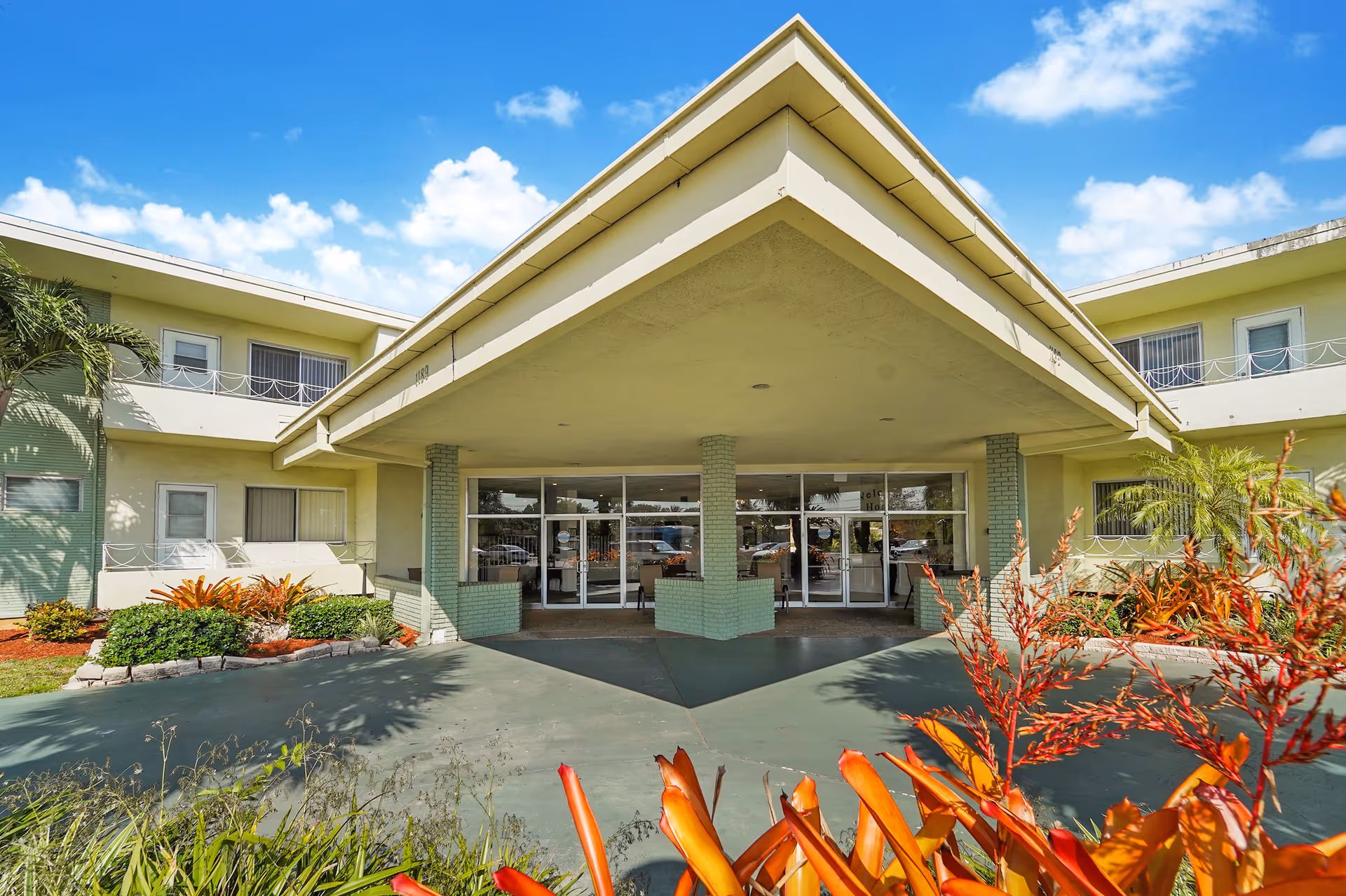 Oasis at Margate building exterior featuring a wide covered entrance and glass doors.
