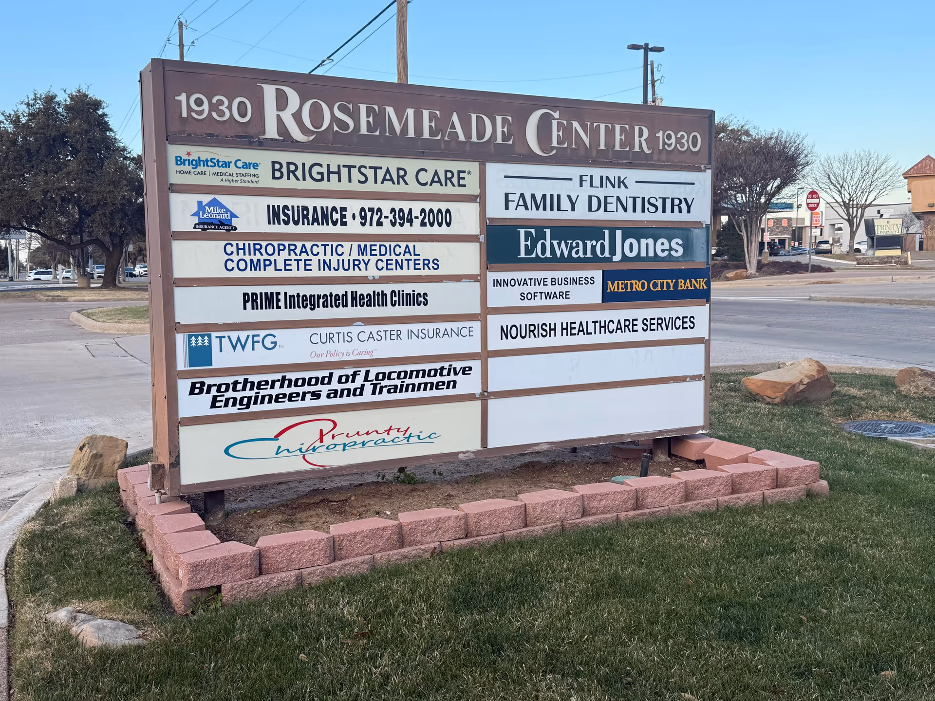Outdoor signboard listing multiple businesses, including Nourish Healthcare Services.
