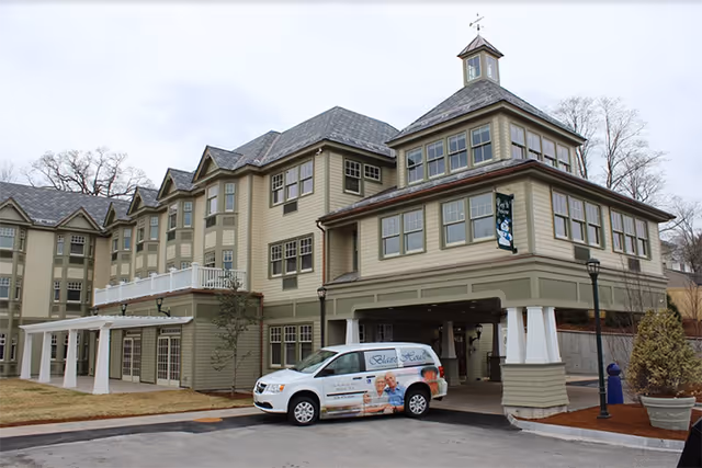 Exterior view of Blaire House Milford Assisted Living building with a van at entrance.