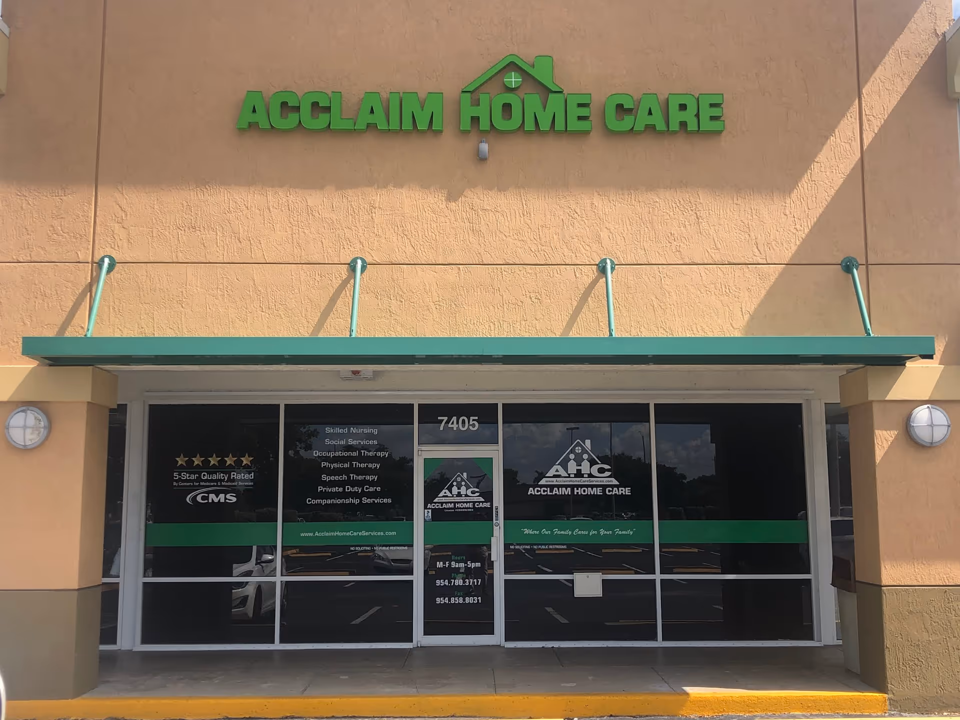 Exterior view of Acclaim Home Care storefront with glass doors and a large green sign.