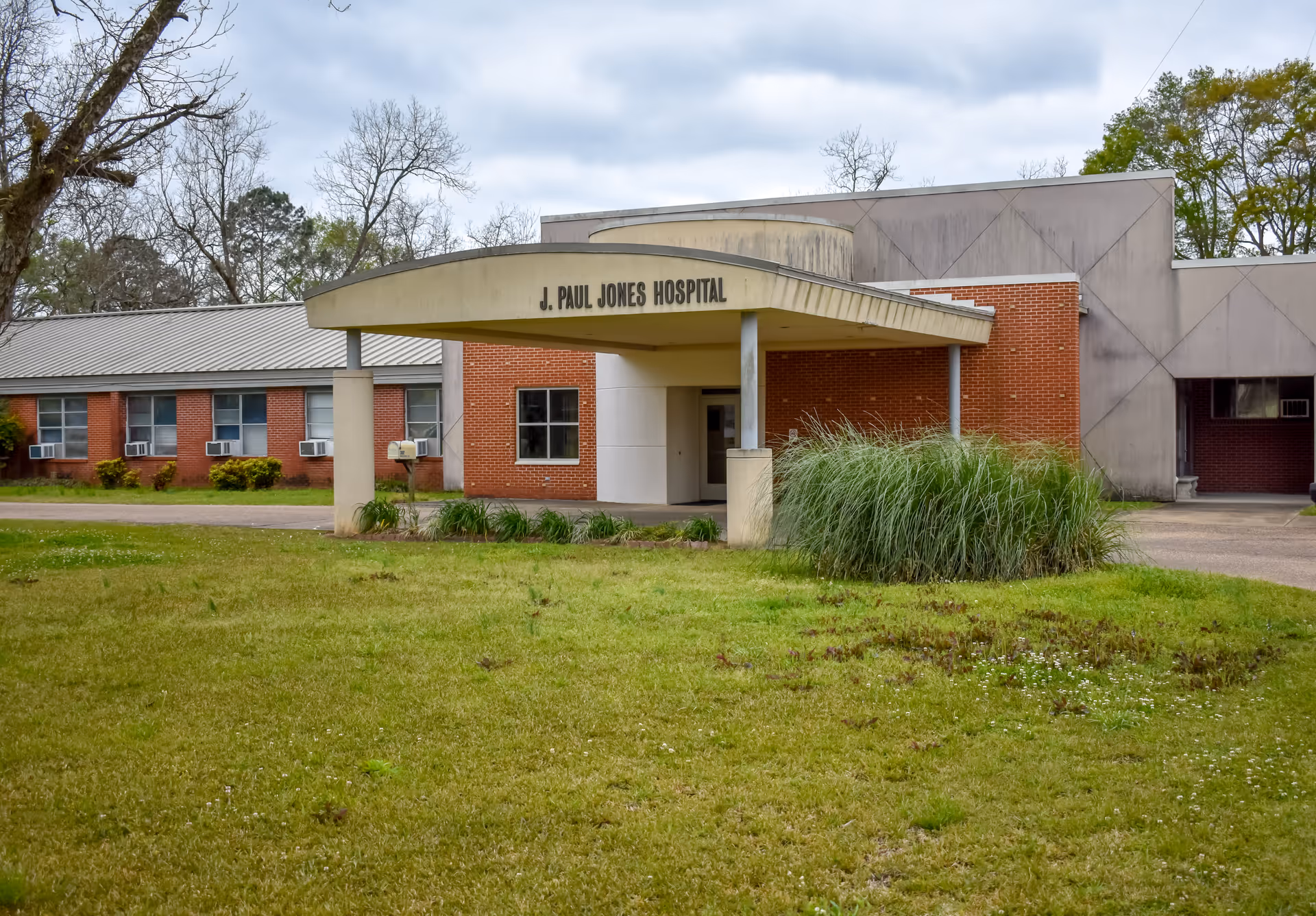 Front view of J. Paul Jones Hospital entrance with brick facade and curved canopy.