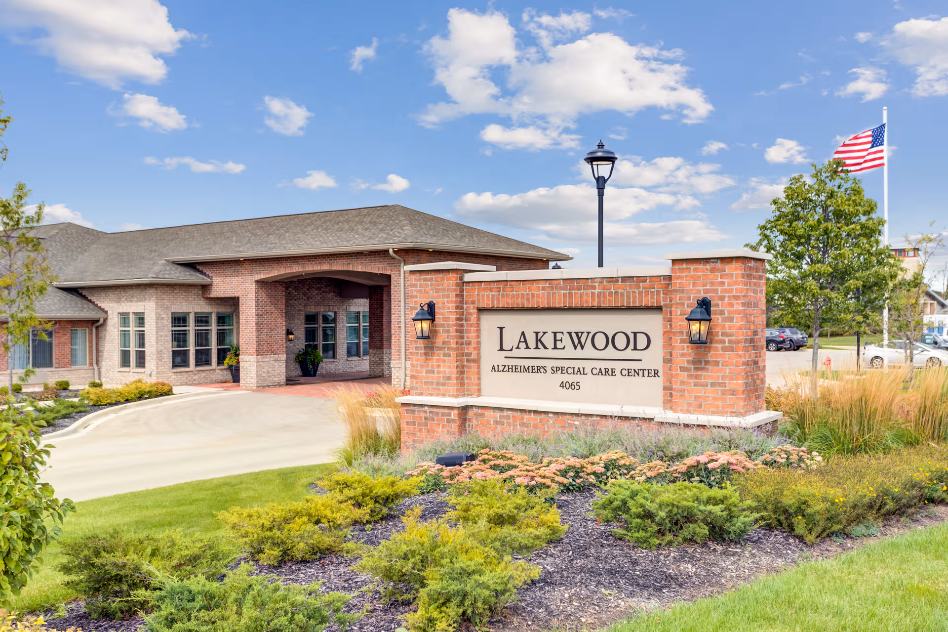 Brick facility entrance with a Lakewood Alzheimer's Special Care Center sign and landscaping.