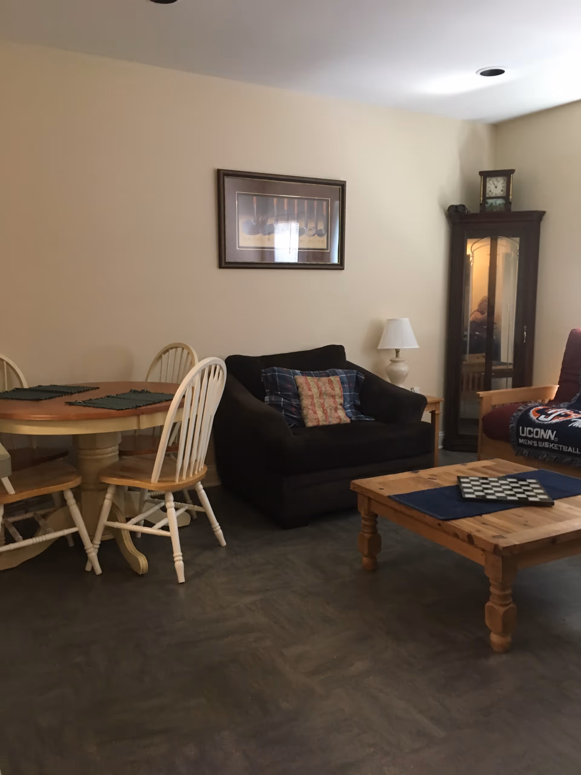 Cozy living room in a senior housing facility with seating and games.