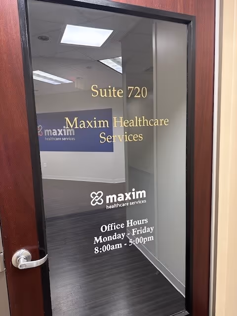 Glass office door labeled Suite 720 with Maxim Healthcare Services and reception area visible.