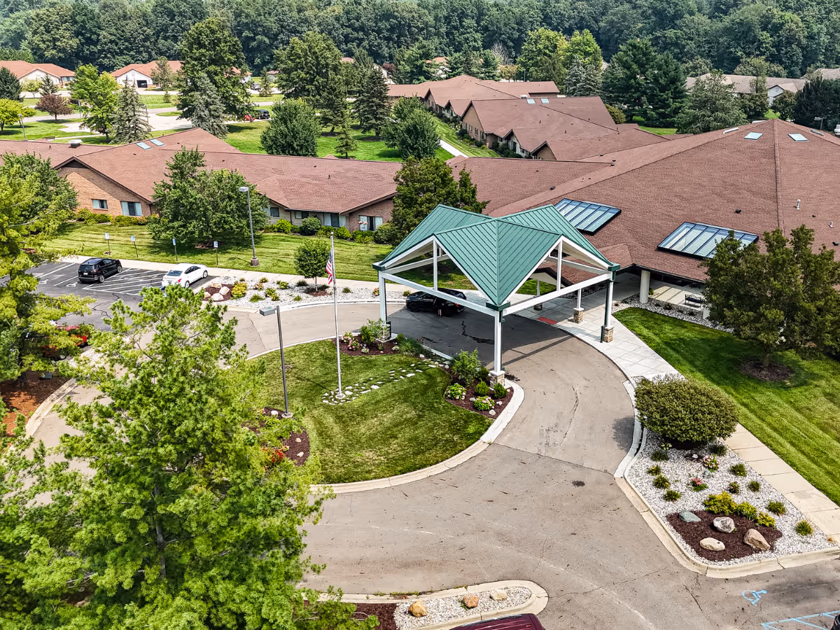 Aerial view of a senior living facility with a green-roofed entrance canopy and landscaped grounds.