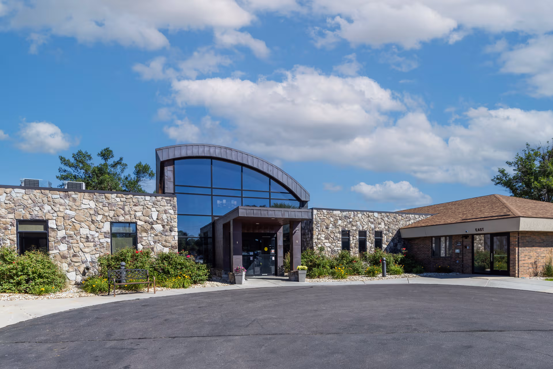 Firesteel Healthcare exterior: stone walls, glass entrance, and landscaped surroundings.