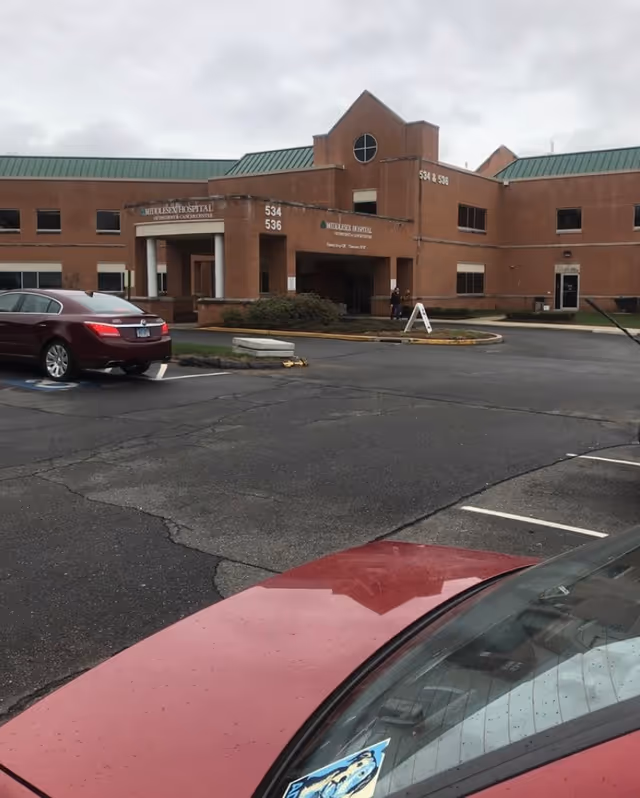 Exterior view of Middlesex Health Cardiac Rehabilitation building with parking lot in front.
