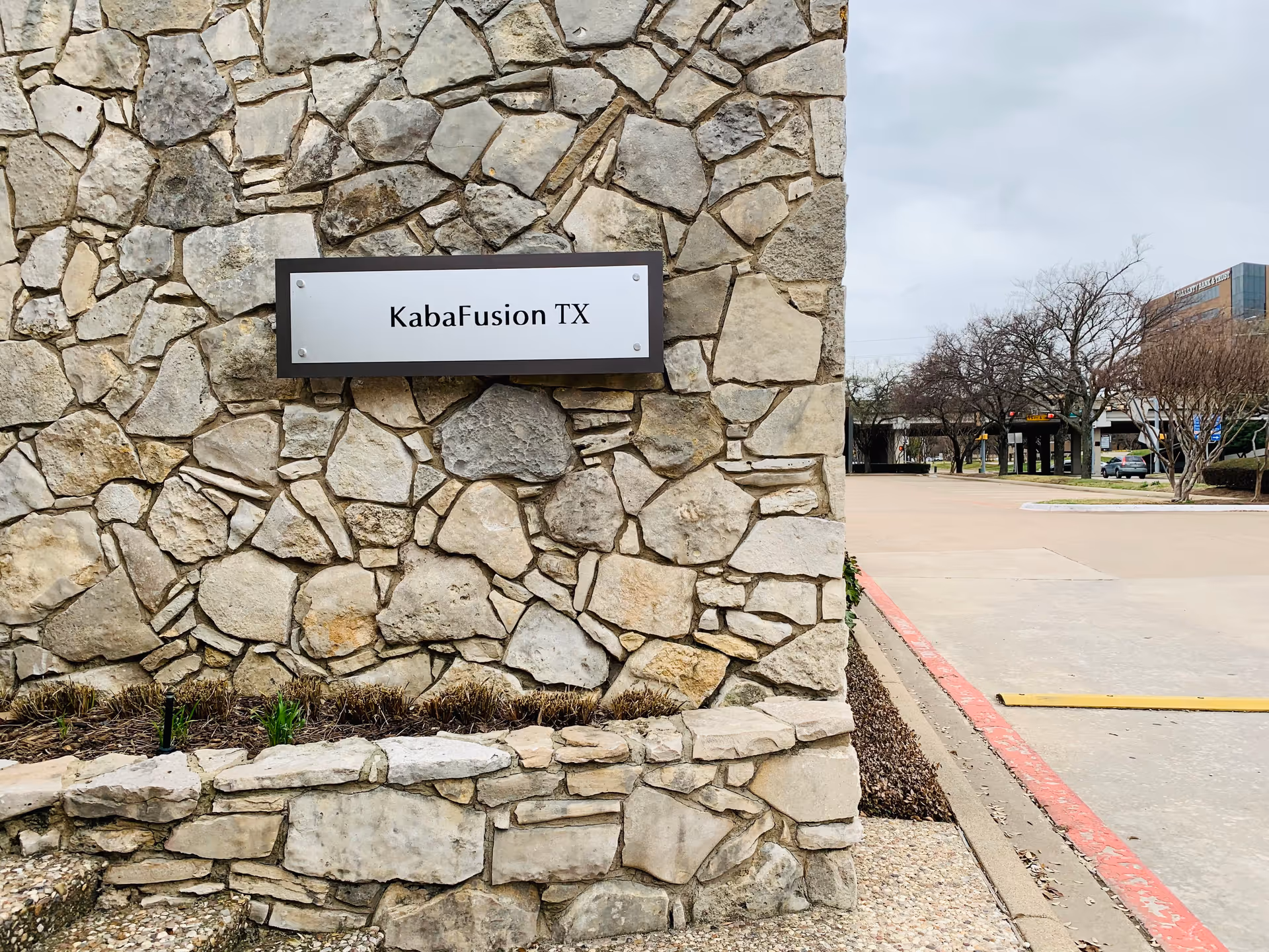 Stone exterior wall with a white KabaFusion TX sign at the entrance.