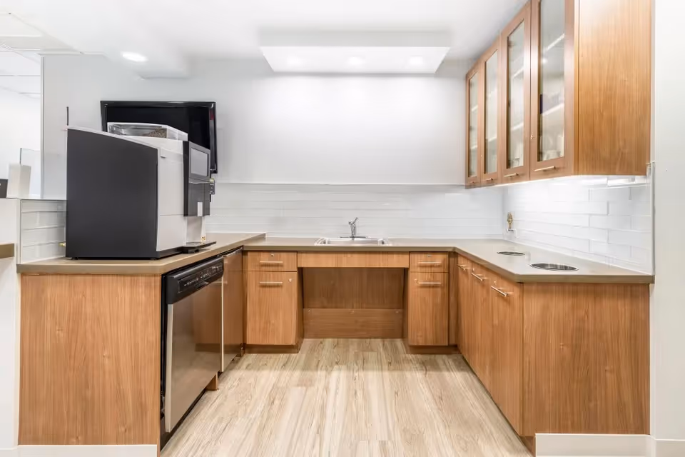 L-shaped kitchen with wooden cabinets, white tile backsplash, and stainless appliances.