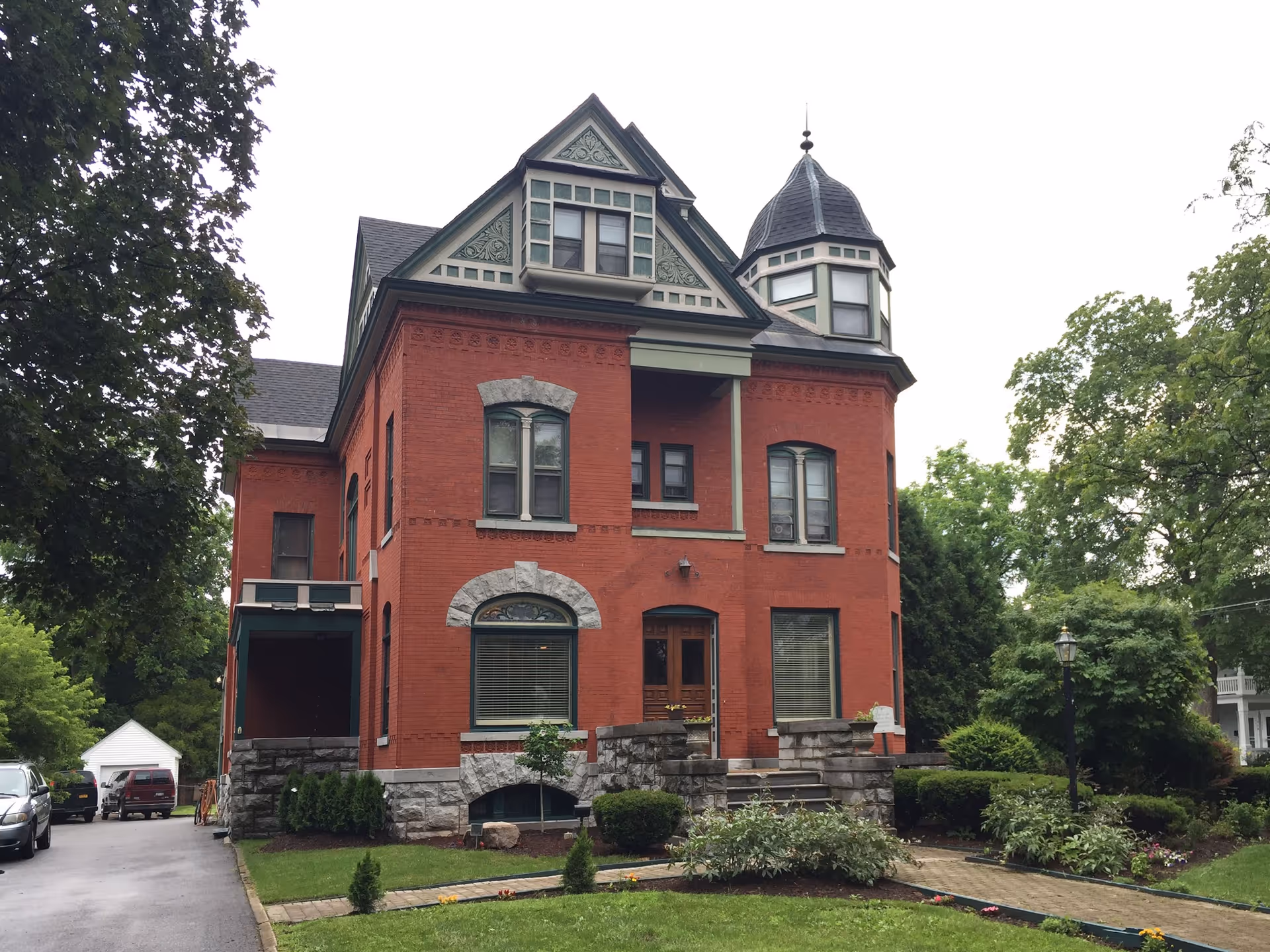 Front view of a red brick Victorian-style building with a stone foundation.