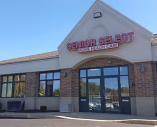 Front exterior of Senior Select Home Health Care building with brick facade and glass entrance.