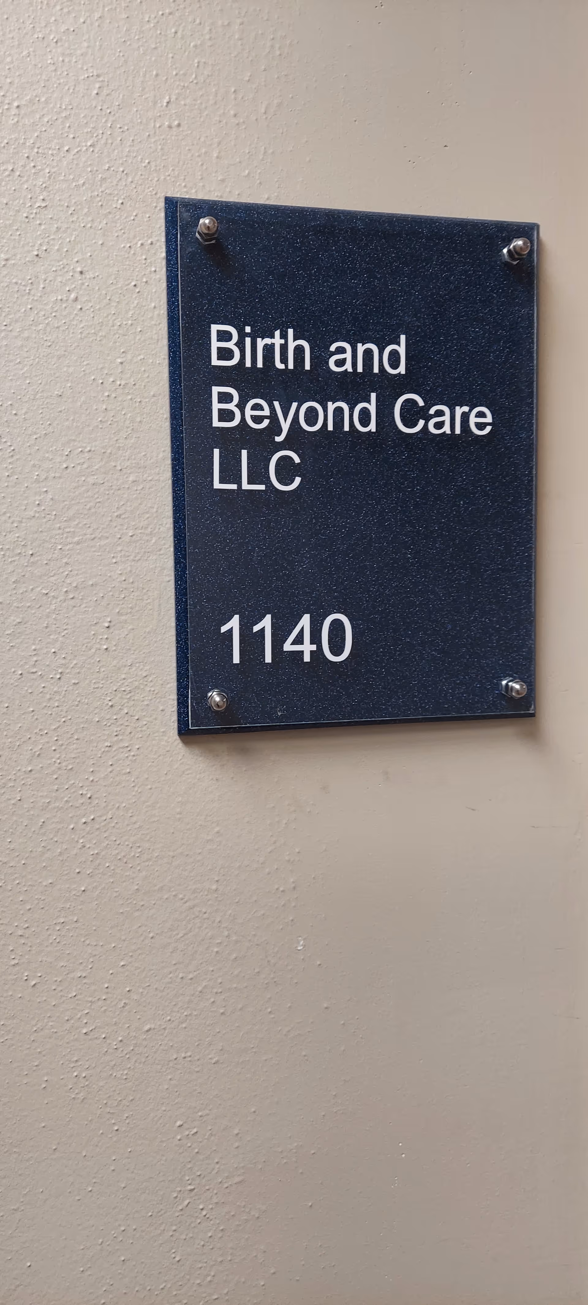 Sign on beige wall reads Birth and Beyond Care LLC with number 1140.