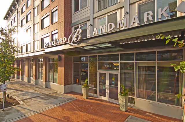 Exterior view of a brick building with glass entry and Ballard Landmark signage.