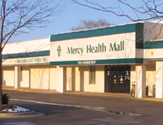 Exterior view of Mercy Health Mall storefronts; no people visible.