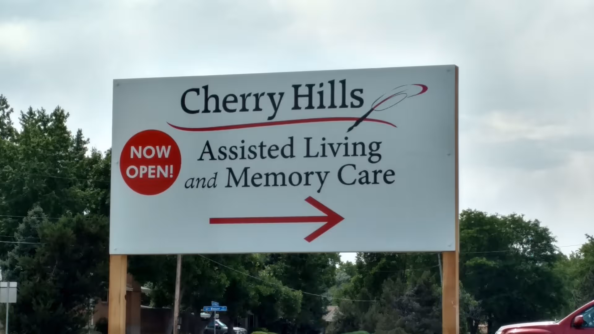A large outdoor sign reads Cherry Hills Assisted Living and Memory Care with a red arrow.