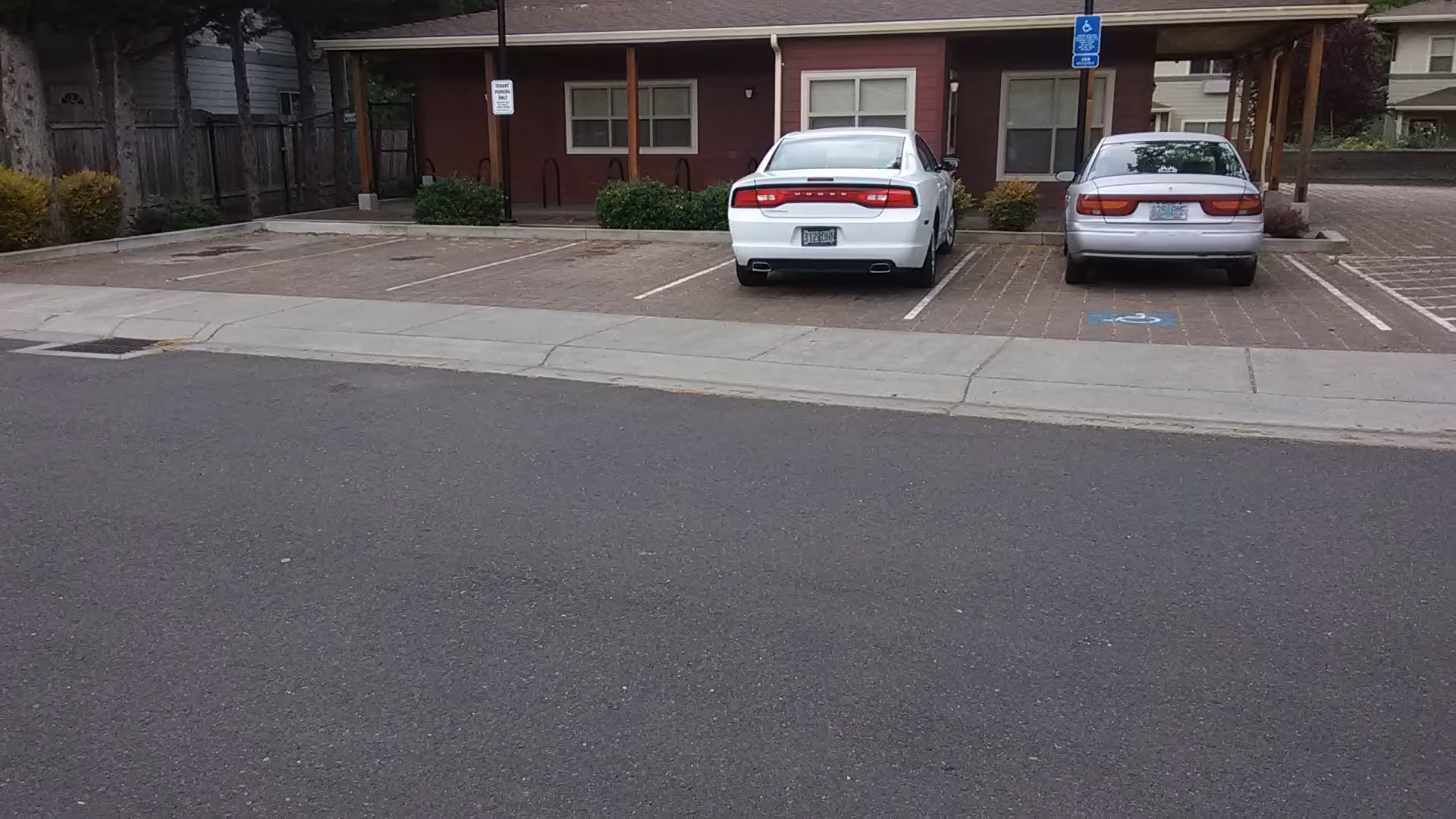 Exterior view of Cedars senior living facility with parked cars in front.