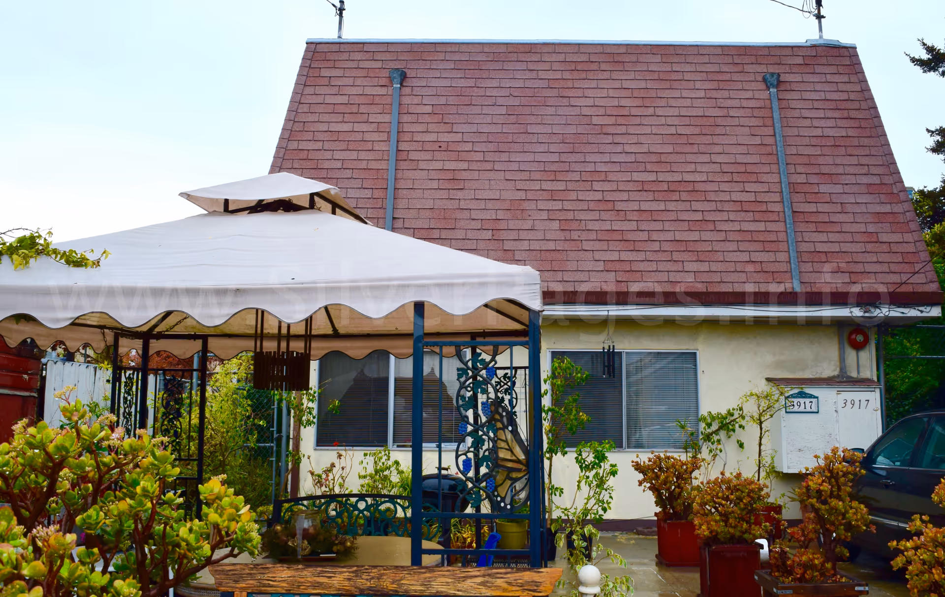 Exterior view of Opal Care facility with a white canopy tent and potted plants.