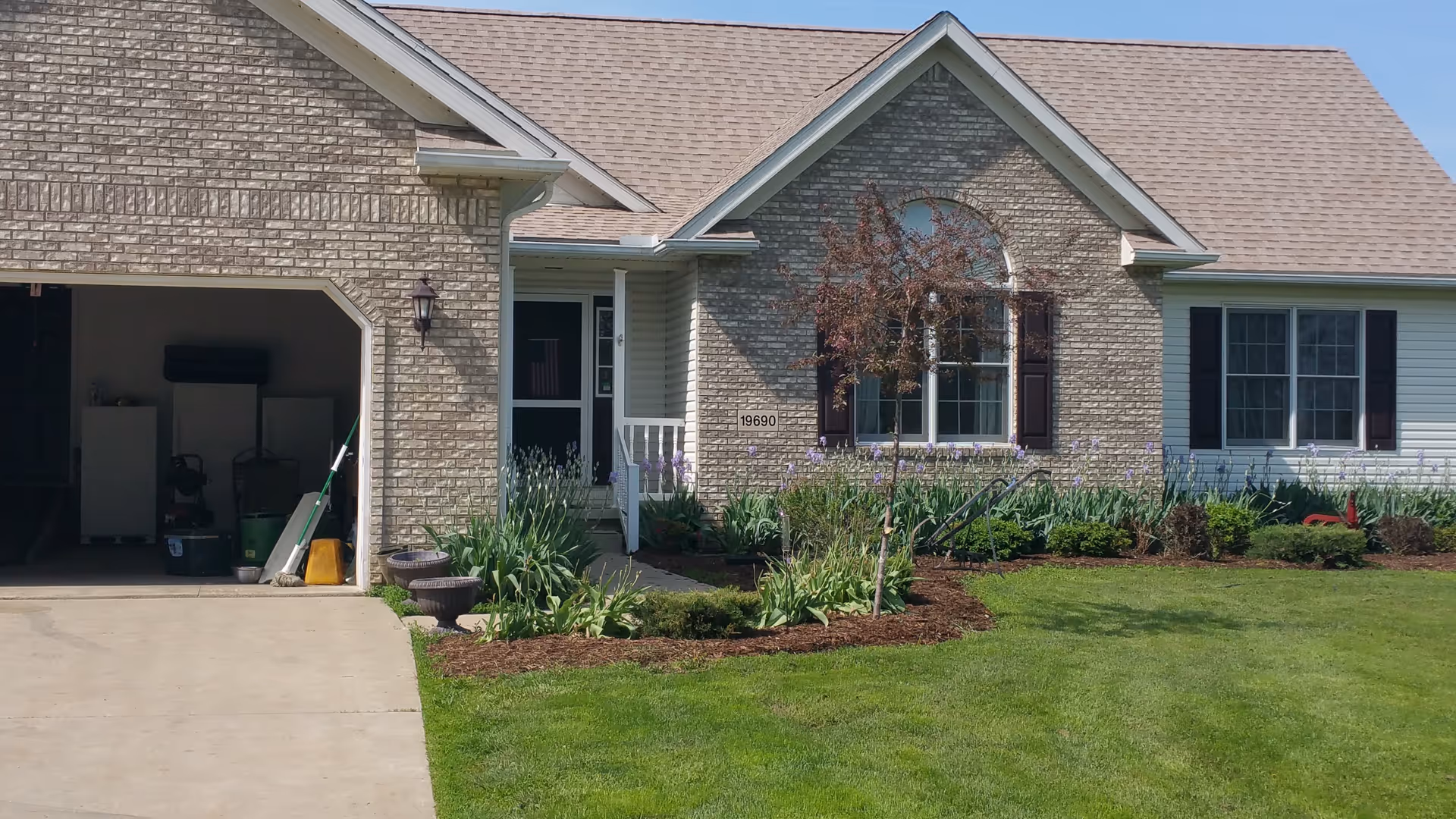 Front view of a single-story brick assisted living facility with manicured lawn