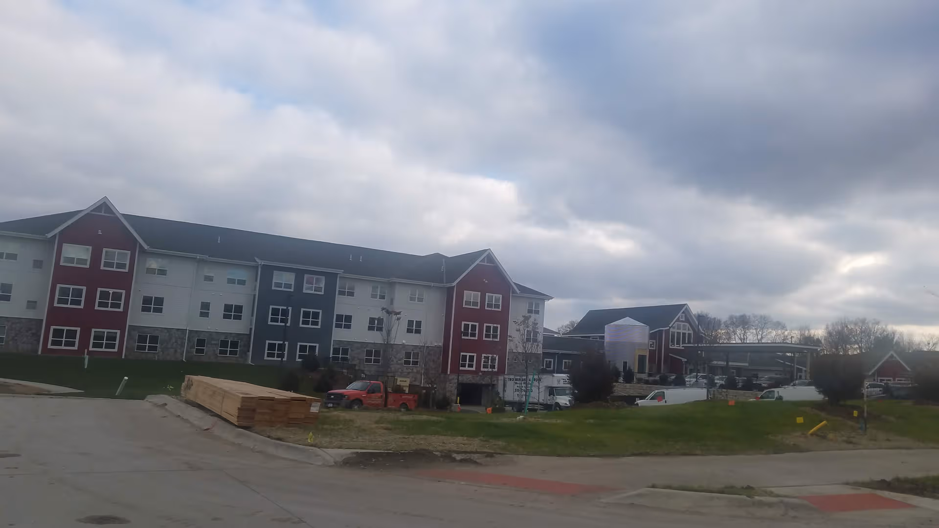Exterior view of Brio of Johnston's multi-color building with construction materials nearby