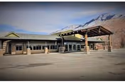 Front exterior of Lomond Peak Nursing and Rehabilitation facility with covered entrance and mountains behind.