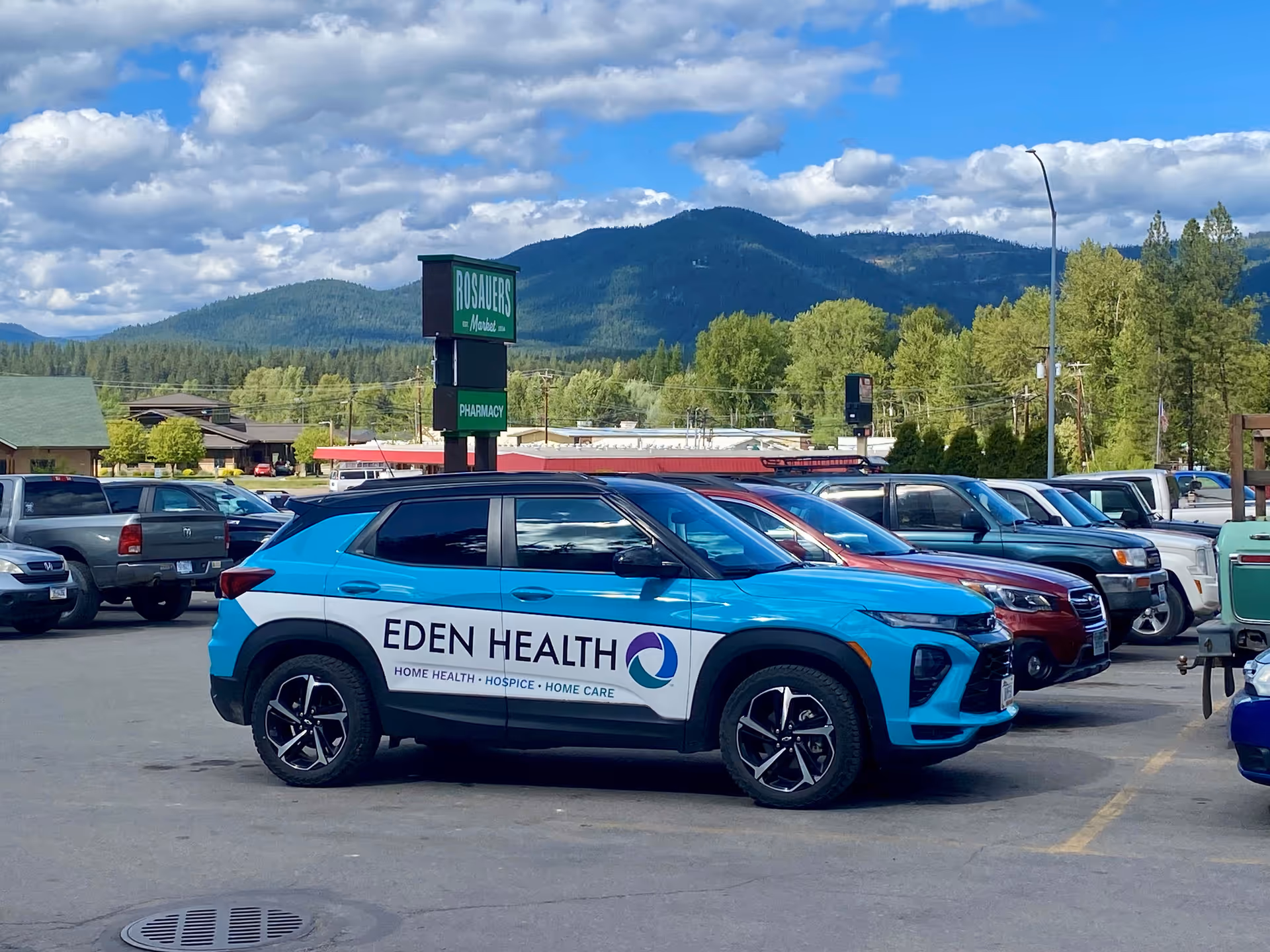 Blue Eden Health vehicle parked in a paved lot with mountain backdrop.