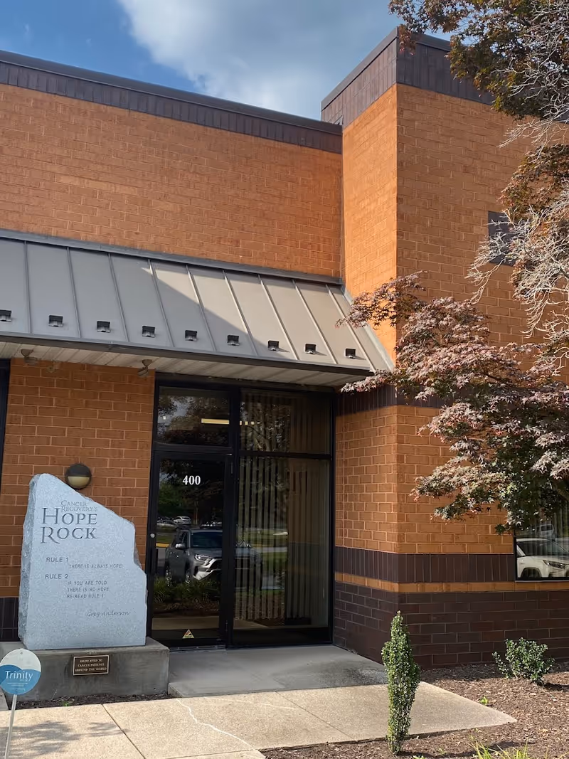 Brick building exterior with glass front entrance, metal awning, and a Hope Rock sign.