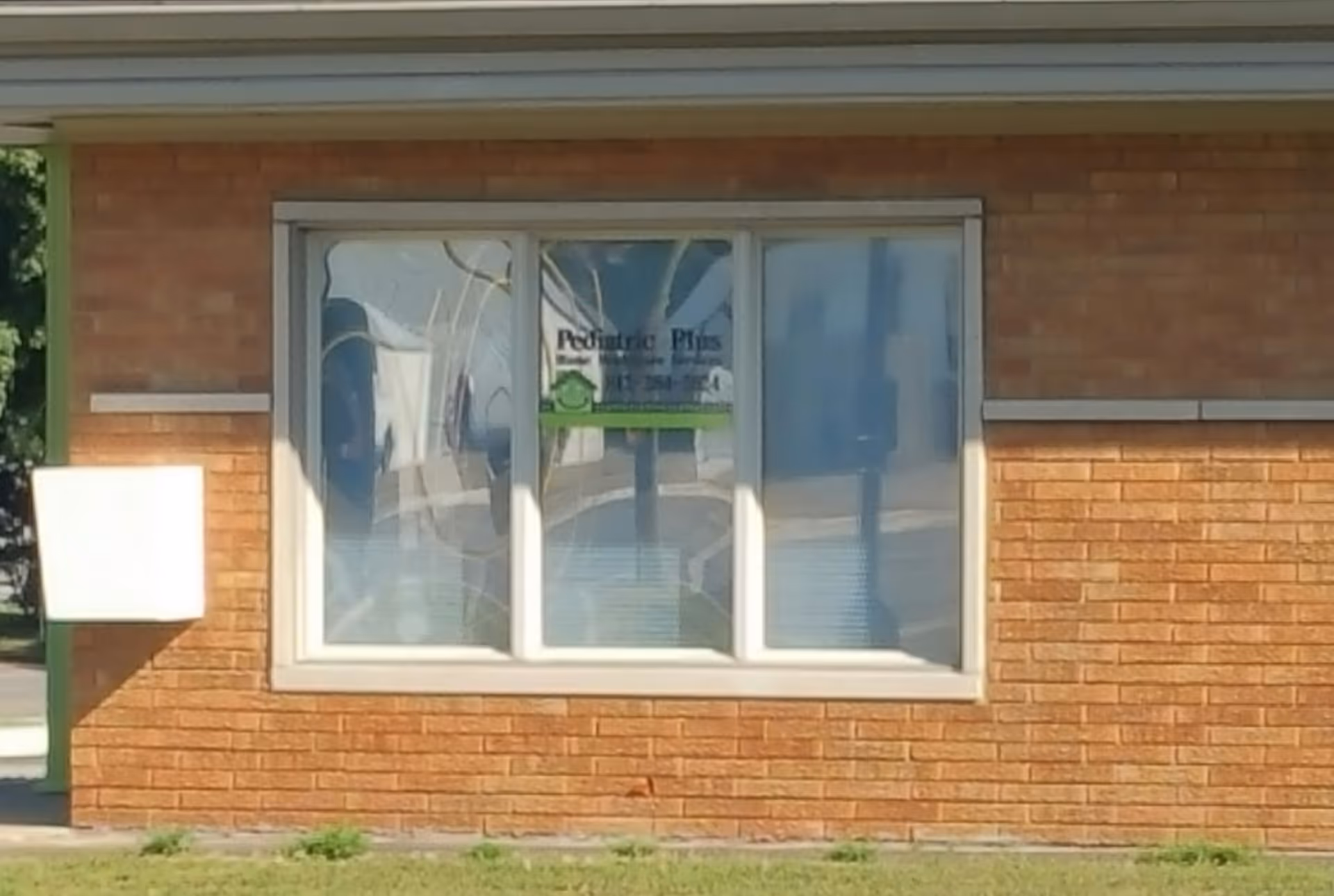 Brick exterior of a building with a large window displaying Pediatric Plus.