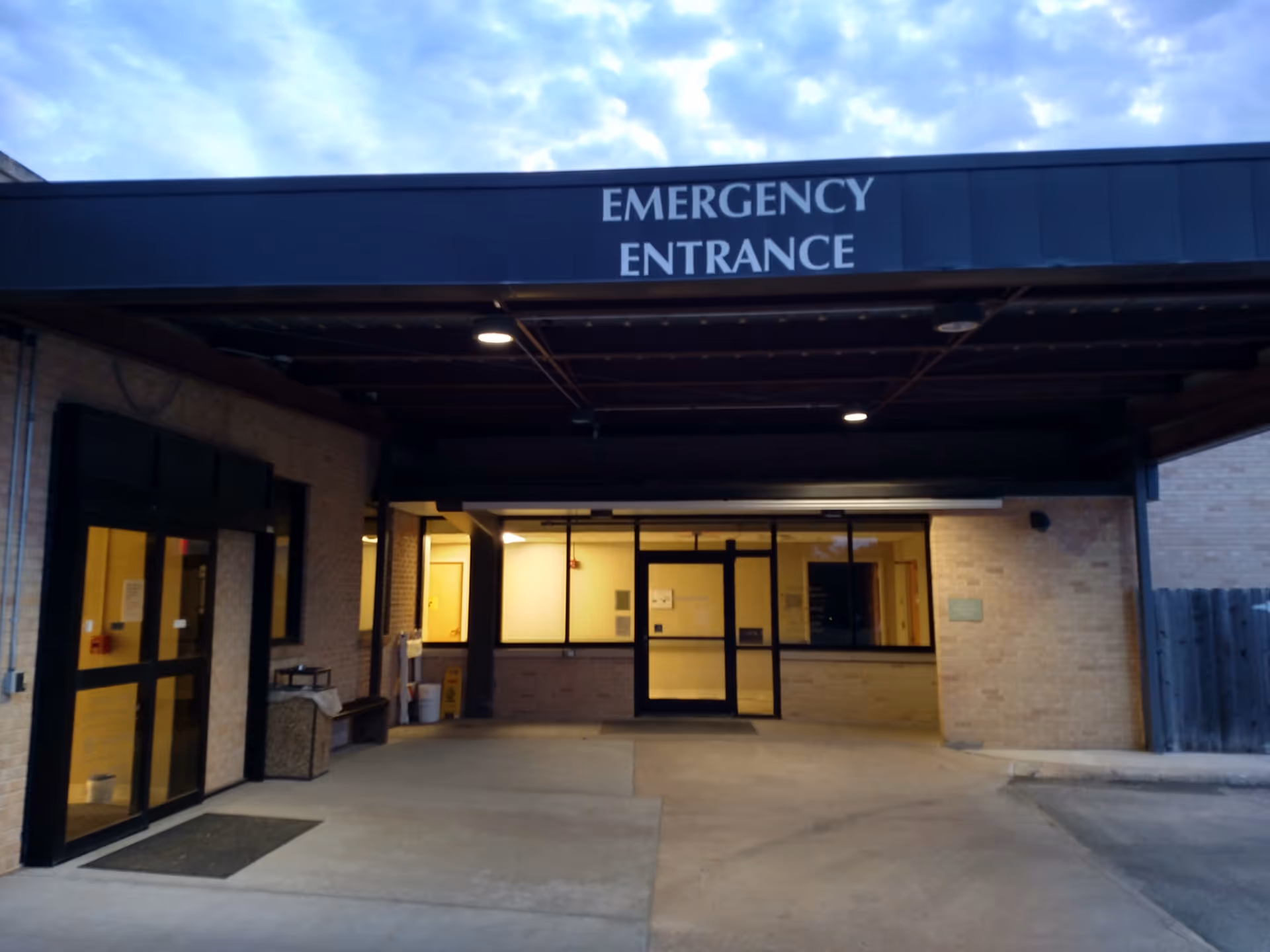 Exterior view of a hospital entrance with an Emergency Entrance sign.