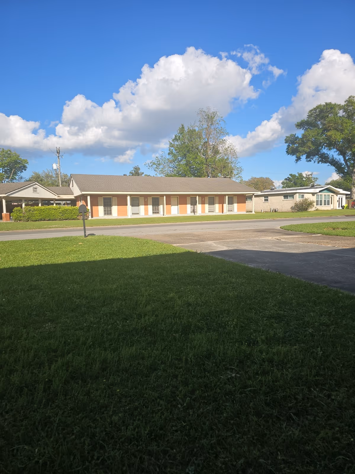Front view of a single-story senior living facility with a green lawn.