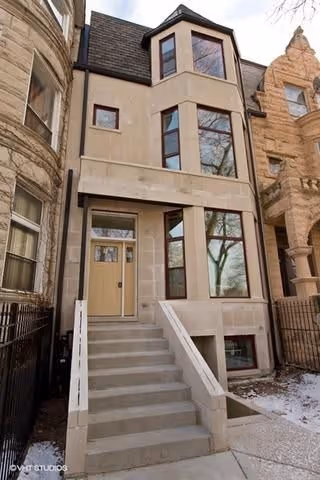 Front view of a townhouse-style senior housing building with stairs to the entrance.