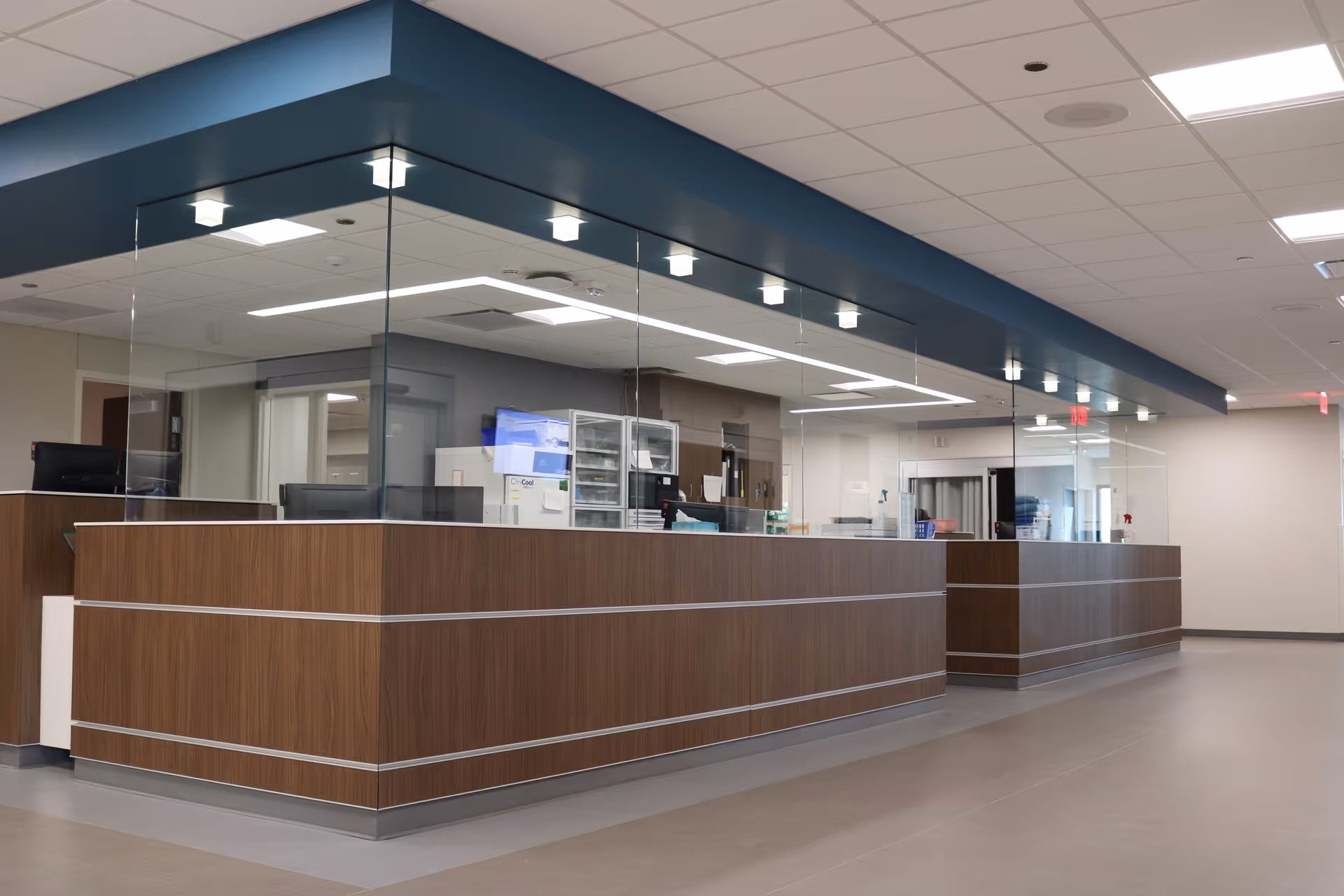 Wide view of Burgess Health Center lobby with a long wooden reception desk and glass partitions.