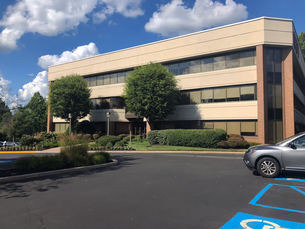 Suncrest Hospice building exterior with beige facade, large windows, and landscaped surroundings