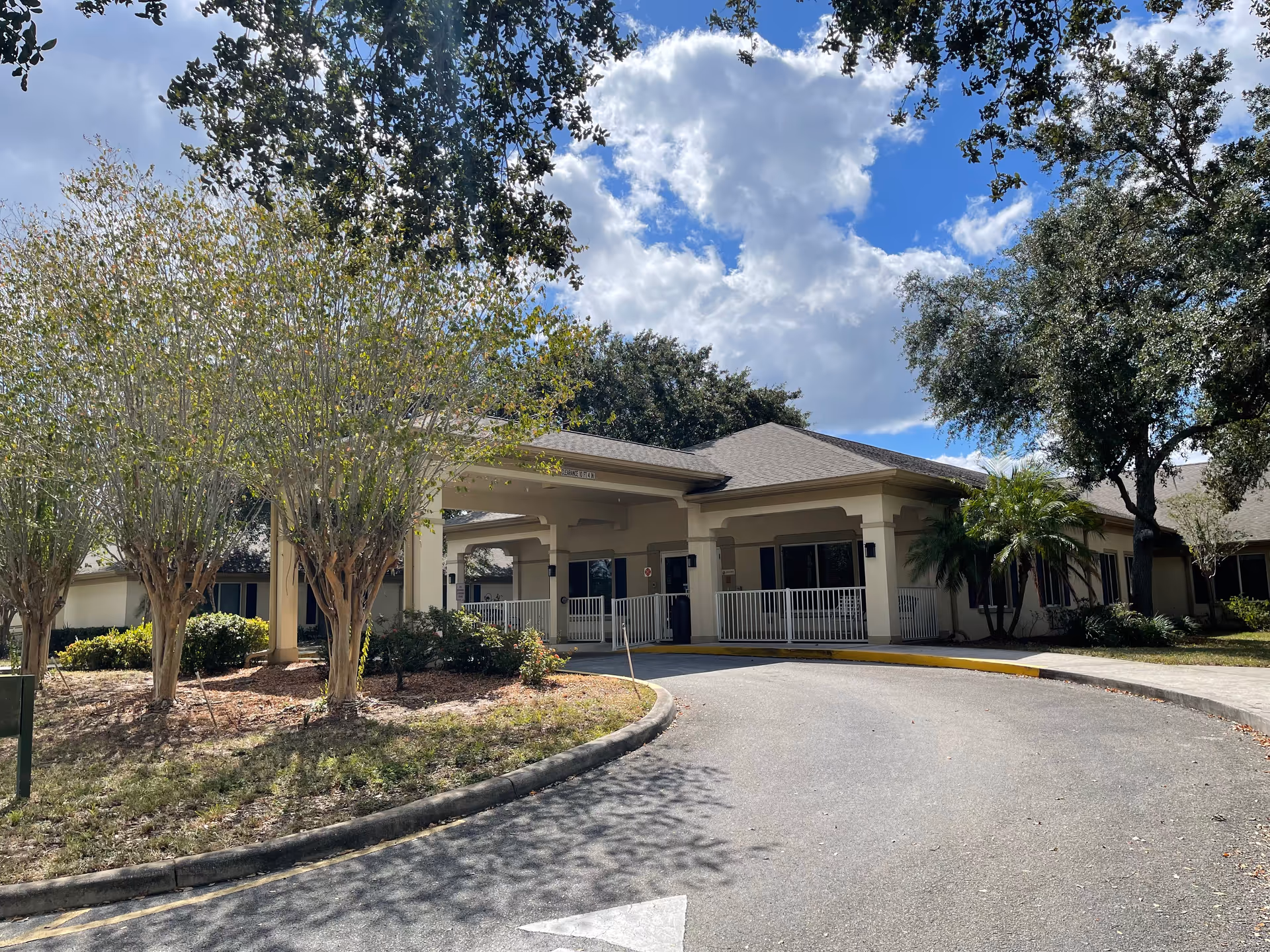Sunny exterior view of Consulate Health Care of Winter Haven's entrance.