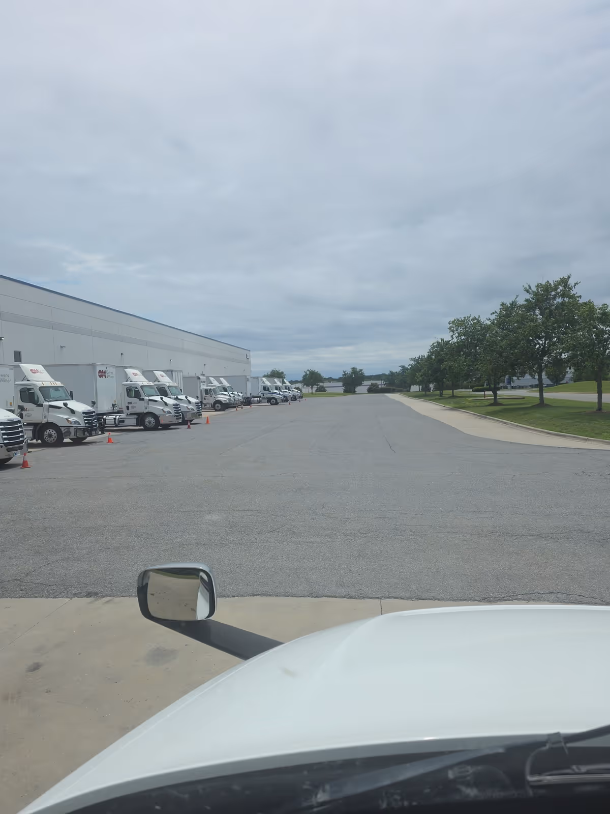 Exterior view of a large warehouse with delivery trucks parked along loading bays.