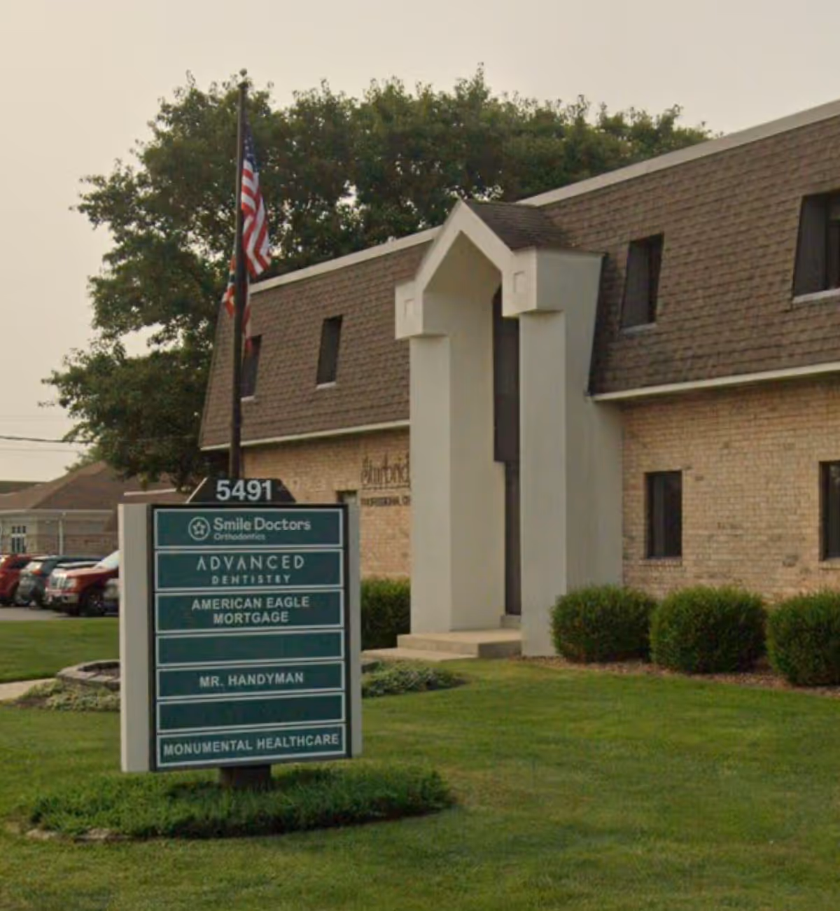 Exterior view of Monumental Healthcare building with a multi-tenant sign and American flag.