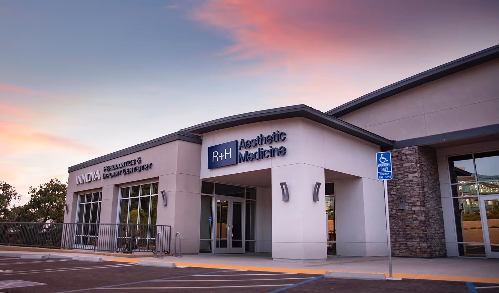Front view of R+H Aesthetic Medicine building with parking and handicapped sign