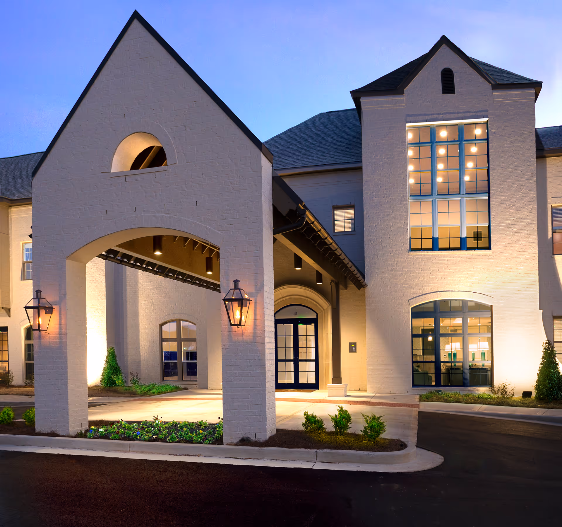 Evening exterior view of The Magnolia at Oxford Commons with illuminated entrance arches.