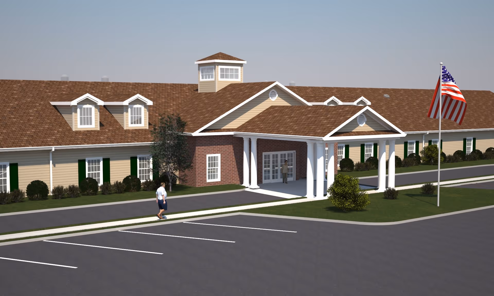 Exterior view of a single-story senior living facility building with beige siding, brown roof shingles, white columns at the entrance, and an American flag on a flagpole in front. There is a parking lot with marked spaces and two people visible near the entrance.