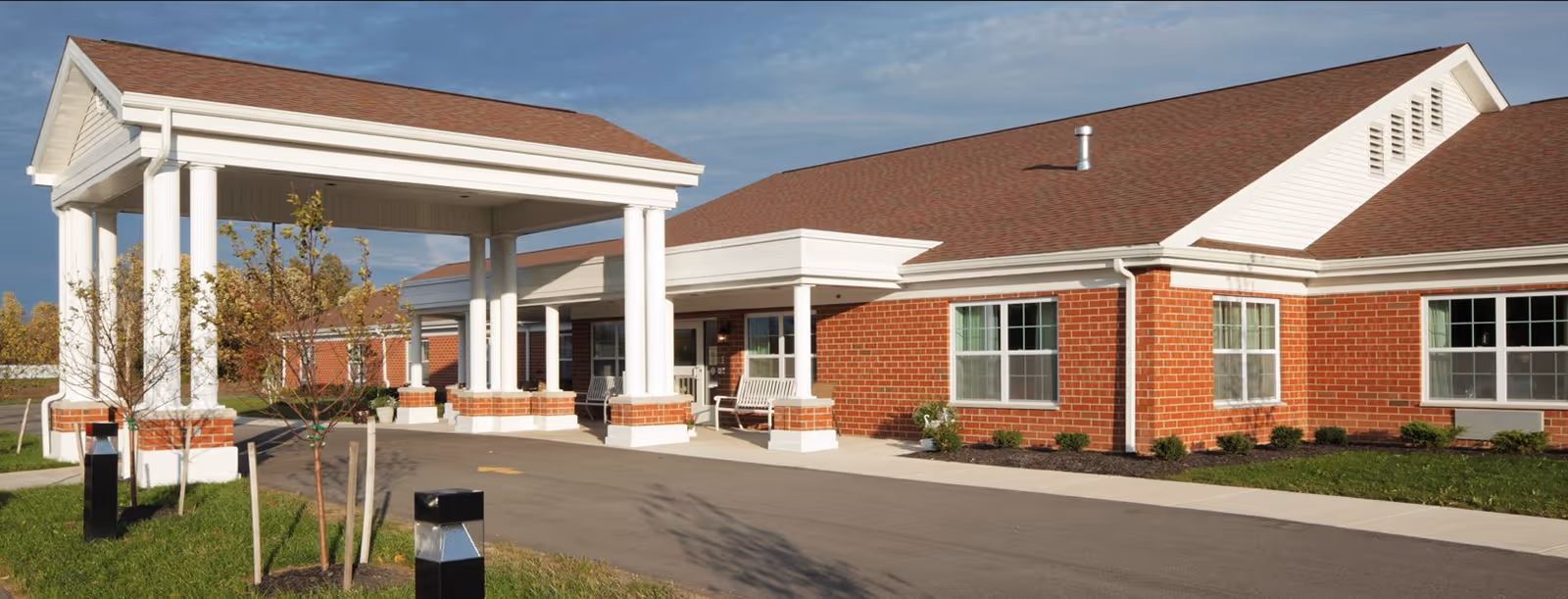 A senior living facility with a covered entrance and brick exterior.