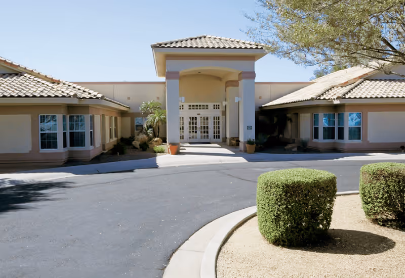 Exterior view of Brookdale North Glendale entrance with drive, pillars, and landscaped shrubs.